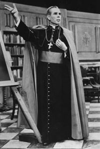 Fulton Sheen on the set of Life is Worth Living. Bishop Sheen appeared in full regalia, surrounded by books. He made ample use of a blackboard to make his points.